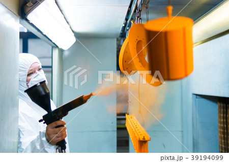 Powder coating of metal parts. A woman in a Powder coating of metal parts. A woman in a 39194099