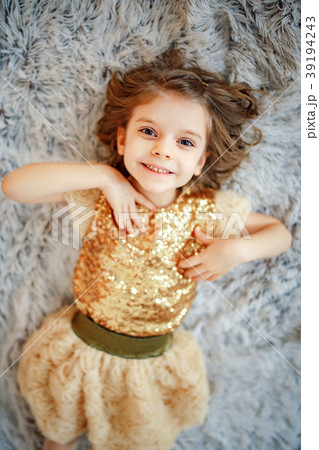 Girl in golden dress on fur 39194243