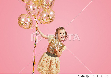 Happy young girl holding bunch of balloons 39194253