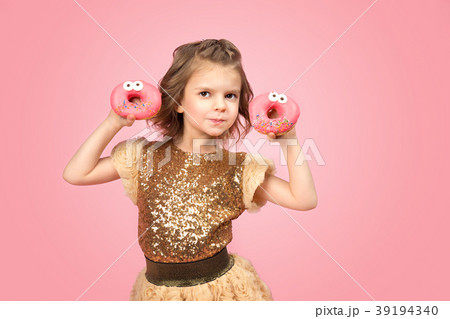 Little girl in dress with donuts 39194340