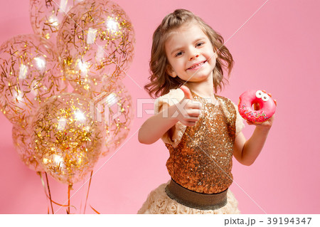 Girl holding donut and gesturing thumb up 39194347