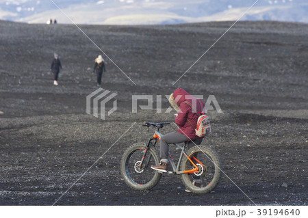 People bike big wheel bicycle on black sand beach  39194640