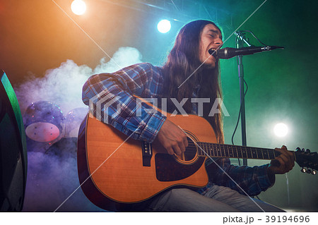 The musician plays an acoustic guitar. Scene 39194696