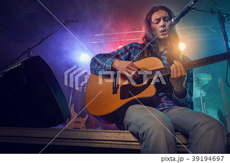 The musician plays an acoustic guitar. Scene 39194697