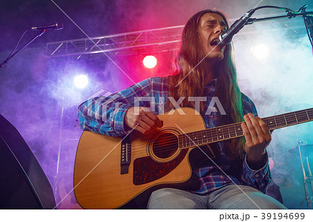 The musician plays an acoustic guitar. Scene 39194699