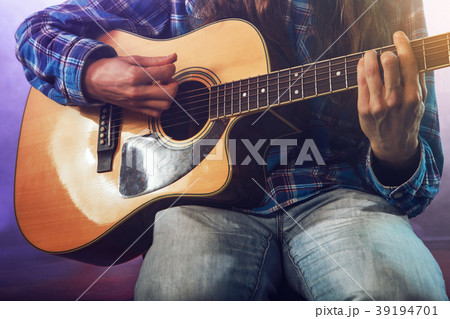 The musician plays an acoustic guitar. Scene The musician plays an acoustic guitar. Scene 39194701