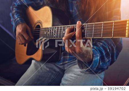 The musician plays an acoustic guitar. Scene 39194702