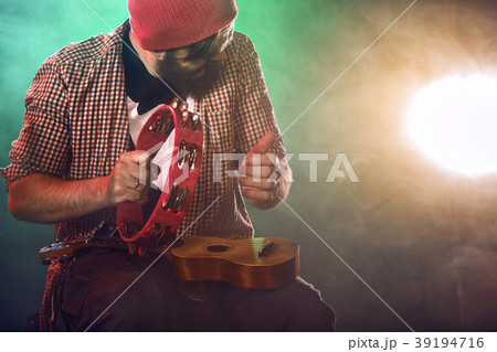 The musician plays an acoustic guitar. Scene The musician plays an acoustic guitar. Scene 39194716