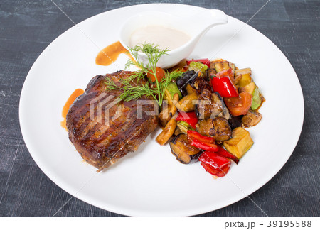 Grilled pork fillet with baked vegetables. 39195588