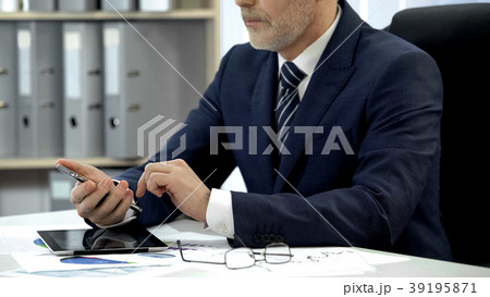 Man in business suit checking email on smartphone Man in business suit checking email on smartphone 39195871
