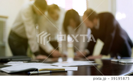 Company colleagues discussing report papers at Company colleagues discussing report papers at 39195875