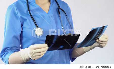 Trauma surgeon holding patient x-ray result making 39196003