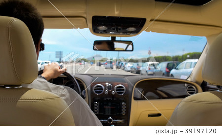 Busy rich male driving car in resort city 39197120
