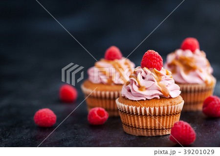 Raspberry and caramel cupcakes on dark background Raspberry and caramel cupcakes on dark background 39201029