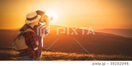 happy couple tourist with photocamera at top of mountain at suns 39202048