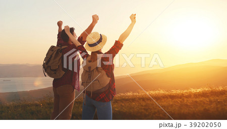 happy couple man and woman tourist at top of mountain at sunset happy couple man and woman tourist at top of mountain at sunset 39202050