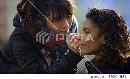 Attentive makeup artist refreshing multiracial Attentive makeup artist refreshing multiracial 39204621