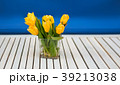 yellow tulips in the glass vase on the white 39213038