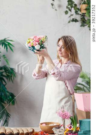 Portrait of florist holding bouquet in hands at 39217352