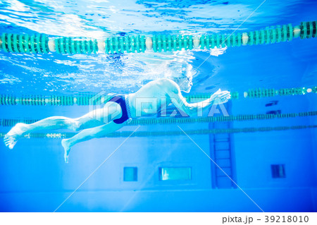 Senior man swimming in an indoor swimming pool. 39218010