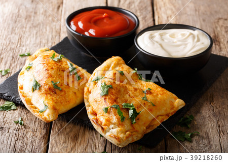 Freshly baked pizza calzone with sauces 39218260