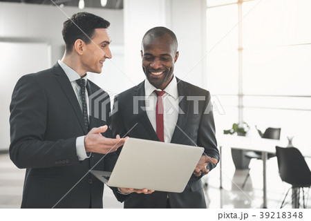 Satisfied executives using gadget in the office 39218348