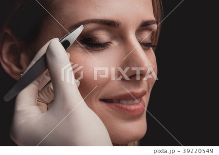 Beaming female visitor having pluck eyebrows 39220549