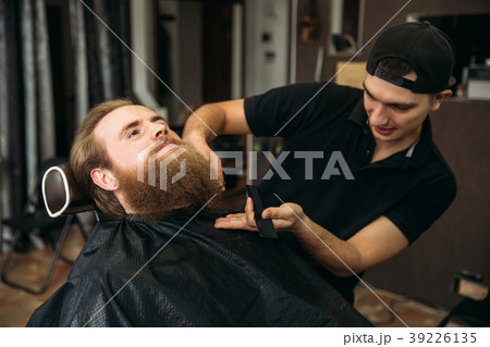 handsome young bearded guy sitting in an armchair 39226135