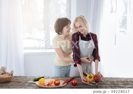 Joyful caring woman helping her girlfriend 39228017