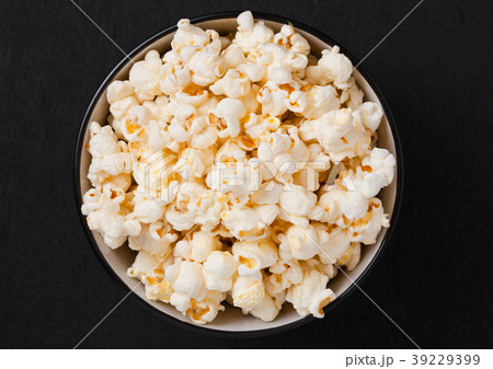 Black bowl with fresh salted popcorn on wood 39229399