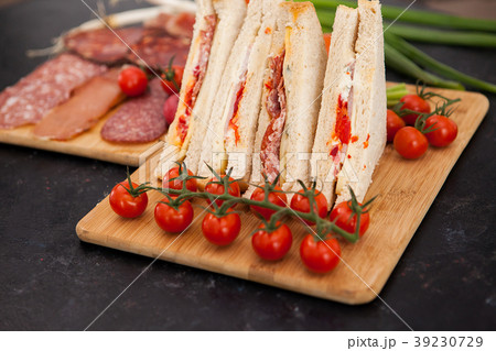 Club sandwiches next to cherry tomatoes, radish Club sandwiches next to cherry tomatoes, radish 39230729