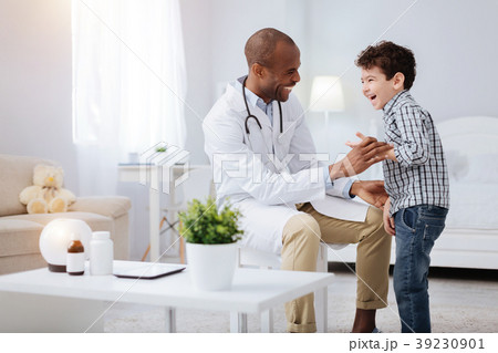 Jovial male doctor making boy laugh 39230901