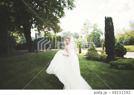 Beautiful bride posing in wedding dress outdoors Beautiful bride posing in wedding dress outdoors 39231592