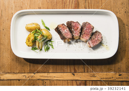 beef and potatoes on white plate with silverware 39232141