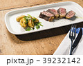 beef and potatoes on white plate with silverware 39232142