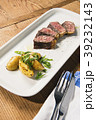 beef and potatoes on white plate with silverware 39232143