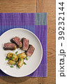beef and potatoes on white plate with silverware 39232144