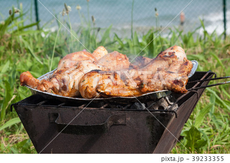 Grilled chicken thighs on the flaming grill. Grilled chicken thighs on the flaming grill. 39233355