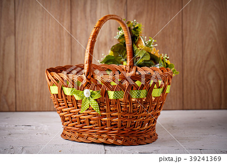 Festive basket decorated with flowers on wooden Festive basket decorated with flowers on wooden 39241369