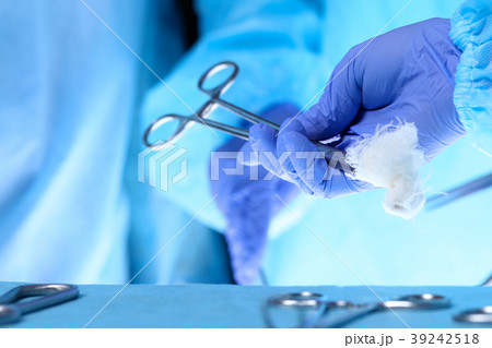 Surgeons hands holding surgical scissors and 39242518