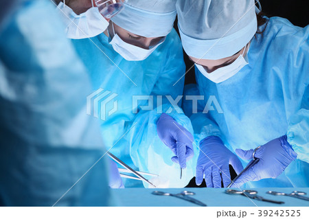 Group of surgeons at work while operating at 39242525