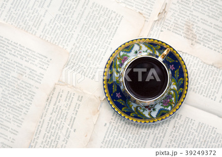 Vintage cup of coffee on old paper sheets or book 39249372