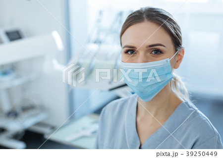 Charming female dentist posing in a face mask Charming female dentist posing in a face mask 39250449