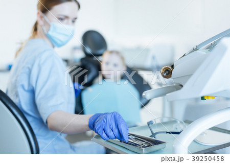 Female dentist taking instrument necessary for Female dentist taking instrument necessary for 39250458