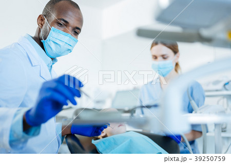 Young male dentist and his nurse carrying out 39250759