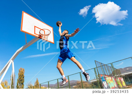 Young Basketball street player making slam dunk Young Basketball street player making slam dunk 39253435