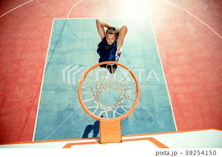 Young man jumping and making a fantastic slam dunk Young man jumping and making a fantastic slam dunk 39254150