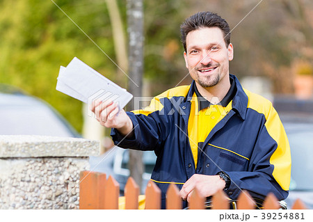 Postman delivering letters to mailbox of recipient 39254881