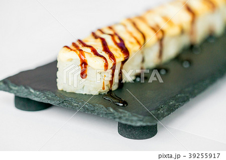 Freshly cooked uncut sushi roll on black board Freshly cooked uncut sushi roll on black board 39255917