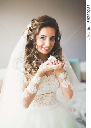 Luxury bride in white dress posing while preparing 39260288